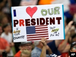 A supporter holds up a sign as President Donald Trump speaks at the Covelli Centre in Youngstown, Ohio, July 25, 2017.