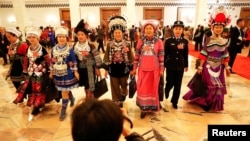 2018年3月5日在北京人民大会堂举行全国人大会议开幕式后，穿着各民族服装的代表们离开会场。