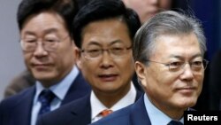 The Democratic Party's candidates for the presidential primary Moon Jae-in, Choi Sung and Lee Jae-myung (R-L) attend an event to declare their fair contest in the party's presidential primary in Seoul, March 14, 2017.