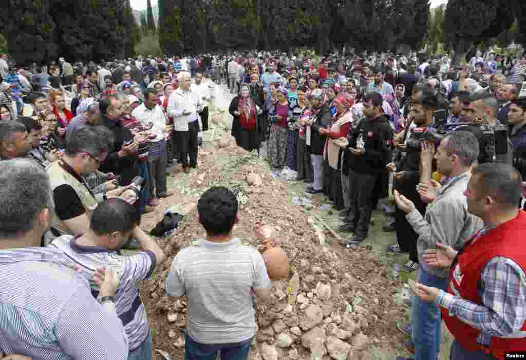 People mourn at the grave of a miner after the burial service, in Soma, western province of Manisa, Turkey, May 15, 2014.