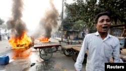 孟加拉伊斯蘭大會黨的抗議者與警察衝突時焚燒了這名男子的汽車 (2013年12月13日)
)