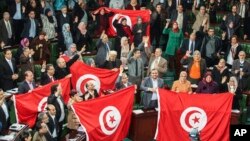 Members of the Tunisian National Constituent Assembly celebrate the adoption of the new constitution in Tunis, Tunisia, Jan. 26, 2014.