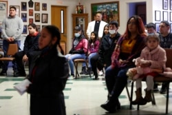 The Rev. Athanasius Abanulo stands behind a group of parishioners as they hold a special ceremony for the Lady of Guadalupe at Holy Family Catholic Church in Lanett, Ala., Dec. 12, 2021.