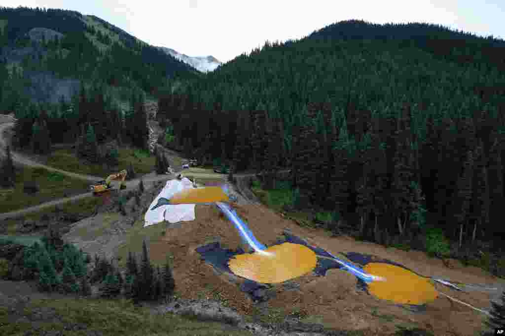 Air mengalir melalui serangkaian kolam retensi yang dibangun untuk menampung dan menyaring logam berat dan bahan kimia dari kecelakaan air limbah tambang Gold King, di katup sekitar 1/4 mil dari hilir tambang, di luar Silverton, Colorado, USA.