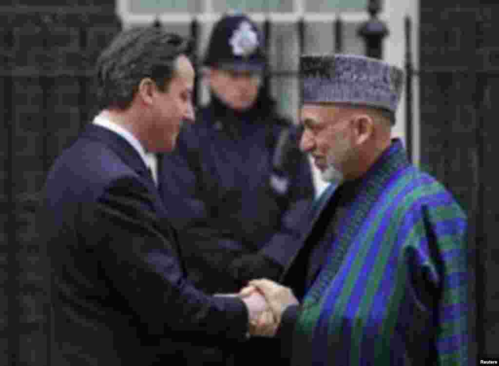 Prime Minister David Cameron (L) greets Afghanistan&#39;s President Hamid Karzai outside Downing Street ,in central London March 1, 2011. REUTERS/Toby Melville