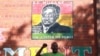 FILE: A supporter of Zimbabwean President Robert Mugabe chants the partys slogan while standing underndeath a portrait of Mugabe in Harare, Sunday, Feb. 21, 2016. (AP Photo/Tsvangirayi Mukwazhi)