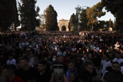 Warga Palestina menghadiri sholat Idul Fitri, yang menandai akhir bulan suci Ramadhan, di kompleks yang menampung masjid al-Aqsa, yang dikenal oleh Muslim sebagai Tempat Suci dan bagi orang Yahudi sebagai Temple Mount, di Kota Tua Yerusalem, 13 Mei 2021.