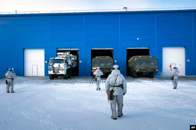 In this photo taken on April 3, 2019, a Russian military's Pansyr-S1 air defense system, left, and two Bastion missile launchers, right, leave a garage during a military drill on Kotelny Island.