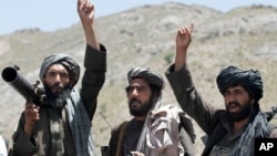 FILE - In this May 27, 2016, photo, Taliban fighters react to a speech by their senior leader in the Shindand district of Herat province, Afghanistan.