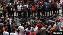 People gather at the scene of a car bomb attack in Baghdad's mainly Shi'ite district of Sadr City, Iraq, May 11, 2016.