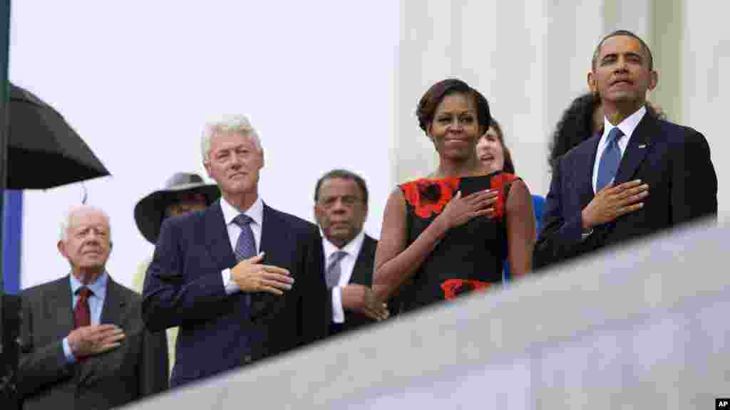 From left, former President Jimmy Carter, former President Bill Clinton, former U.N. Ambassador Andrew Young, first lady Michelle Obama, and President Barack Obama stand for the national anthem during a ceremony commemorating the 50th anniversary of the March on Washington,&nbsp; Aug. 28,2013.