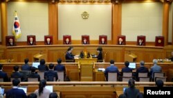 FILE - South Korean acting Constitutional Court's Chief Judge Lee Jung-mi (center) and seven judges during final ruling of President Park Geun-hye's impeachment at the Constitutional Court in Seoul, South Korea, March 10, 2017.