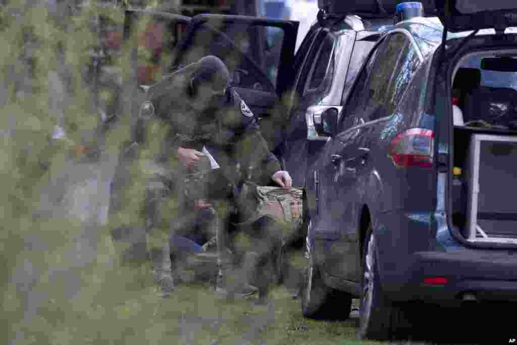 Dutch counterterrorism police install a camera on a sniffer dog as they prepare to enter a house after a shooting incident in Utrecht, Netherlands.