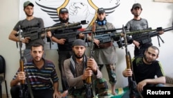 Free Syrian Army fighters pose for a photograph with their weapons in the old city of Aleppo, Sept. 16, 2013.