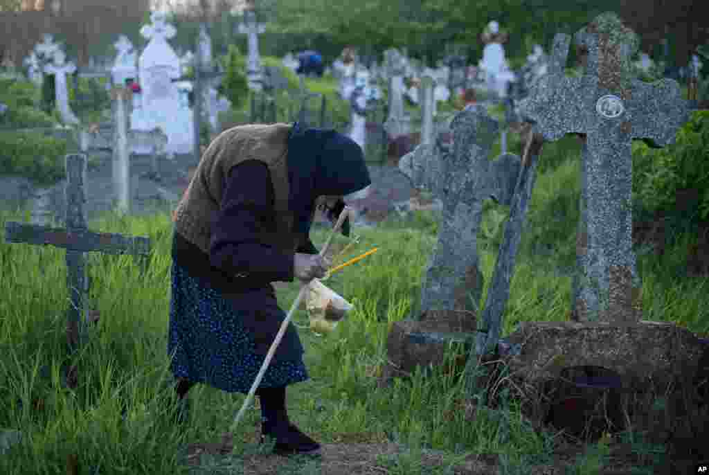 این زن پیر در قبرستانی در جنوب رومانی به دنبال قبر بستگانش است.&nbsp;