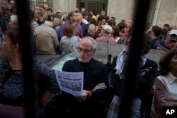 A man stands in the street reading a pamphlet urging people to vote during an event to support the Catalonia independence referendum in Madrid, Spain, Sept. 17, 2017.