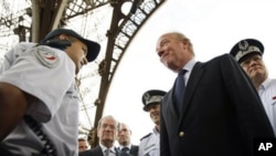 France's Interior Minister Brice Hortefeux, second right, meets security forces at the Eiffel Tower in Paris, Thursday Sept. 16, 2010.