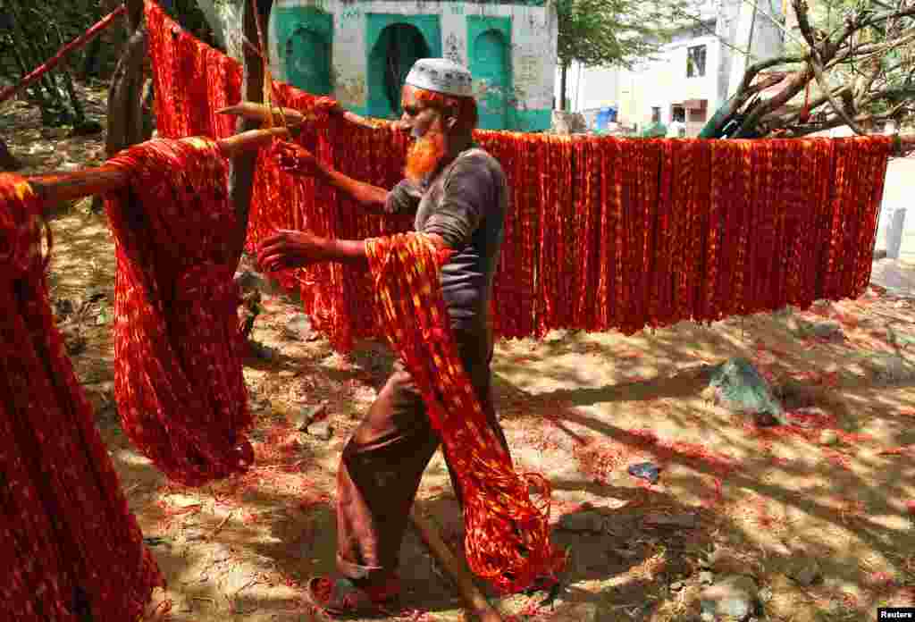Seorang pekerja mengeringkan &quot;Kalava&quot; (atau benang suci Hindu) setelah memberi warna di kota Ajmer, India.