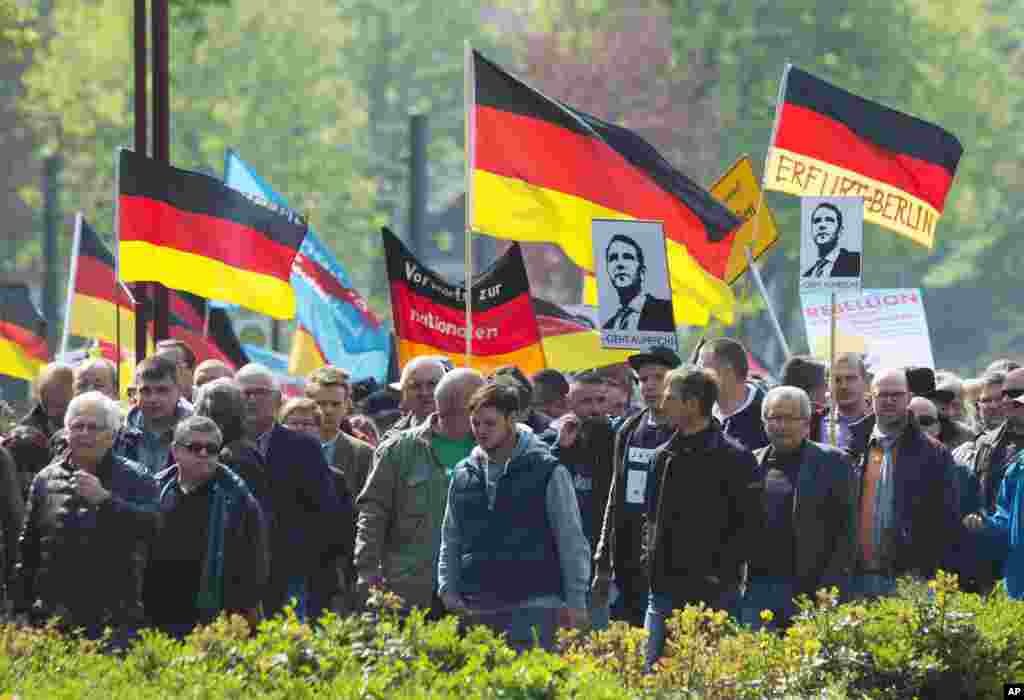 Orang-orang memegang bendera saat ikut demo yang diprakarsai oleh partai nasionalis Jerman, AfD (Alternatif untuk Jerman) pada Hari Buruh di Erfurt, Jerman tengah, 1 Mei 2017.