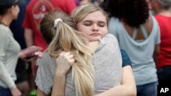 Students hug outside a staging area at the First Baptist Church of Ocala as parents arrive to pick them up after a shooting incident at nearby Forest High School in Ocala, Florida, April 20, 2018.