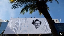 Workers place a banner depicting actress Ingrid Bergman on the Palais during preparations for the 68th international film festival, Cannes, southern France, May 11, 2015.