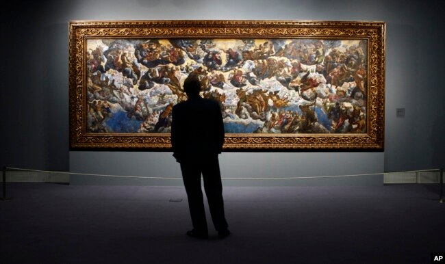 FILE - A man looks at "The Coronation of the Virgin, The Paradise" a painting by 16th century Venetian artist Tintoretto at the Thyssen-Bornemisza Museum in Madrid, June 7, 2006.
