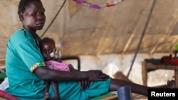 A woman carries her severely malnourished child at a clinic in Doro refugee camp in South Sudan, March 9, 2012. 