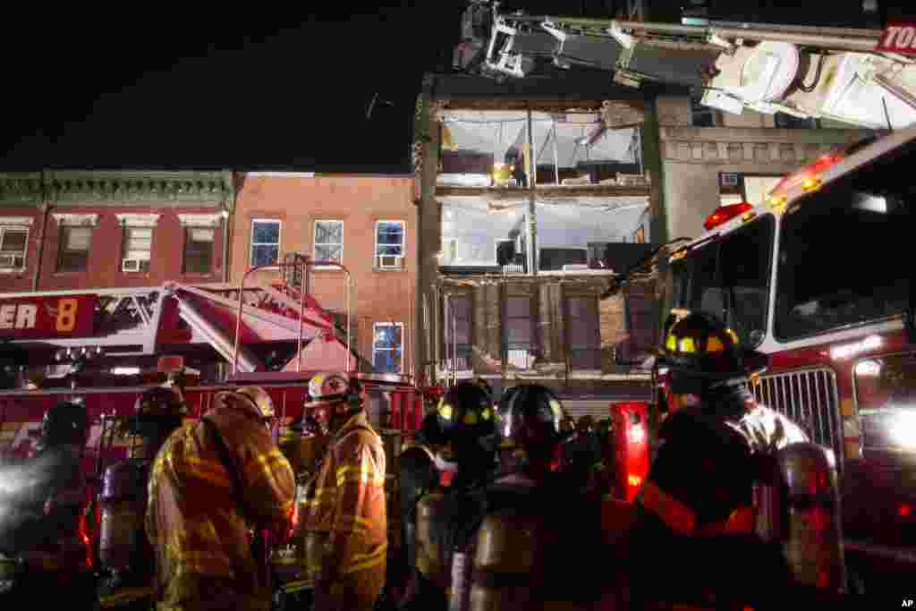 The facade of a four-story building on 14th Street and 8th Avenue collapsed onto the sidewalk as FDNY firefighters respond, October 29, 2012, in New York. 