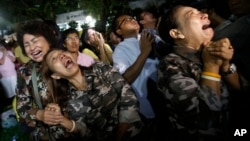Warga Thailand menangis setelah pengumuman meninggalnya Raja Thailand Bhumibol Adulyadej di luar rumah sakit Siriraj di Bangkok, Thailand, Kamis (13/10).