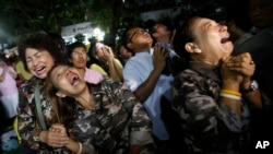 Thai people cry after Royal Palace's announcement outside Siriraj Hospital where King Bhumibol Adulyadej was being treated, in Bangkok, Thailand, Thursday, Oct. 13, 2016.