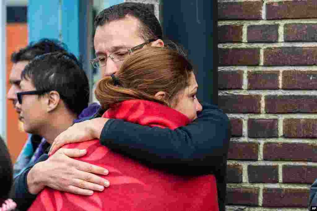 People comfort each other after being evacuated from Brussels airport, after explosions rocked the facility in Brussels, March 22, 2016.