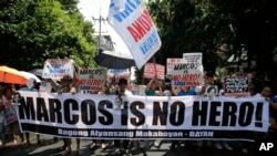 Anti-Marcos protesters hold slogans in a rally outside the Philippine Supreme Court in Manila, Philippines before the court approved the burial of Ferdinand Marcos in Manila's Cemetery of Heroes.