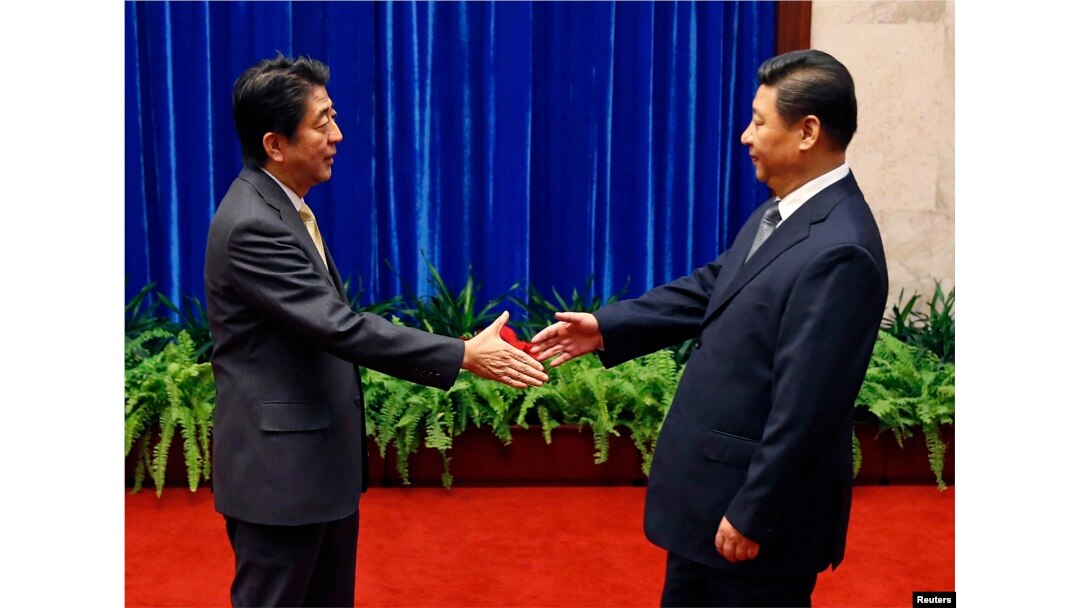 Japan's Prime Minister Shinzo Abe shakes hands with China's President Xi Jinping (R) during their meeting at the Great Hall of the People, in Beijing, Nov. 10, 2014.