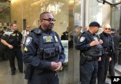 Officers from the Department of Homeland Security's Federal Protective Service stand guard as people demonstrate outside a federal immigration court in Los Angeles, March 6, 2017, protesting the arrest of an immigrant who has been ordered deported.