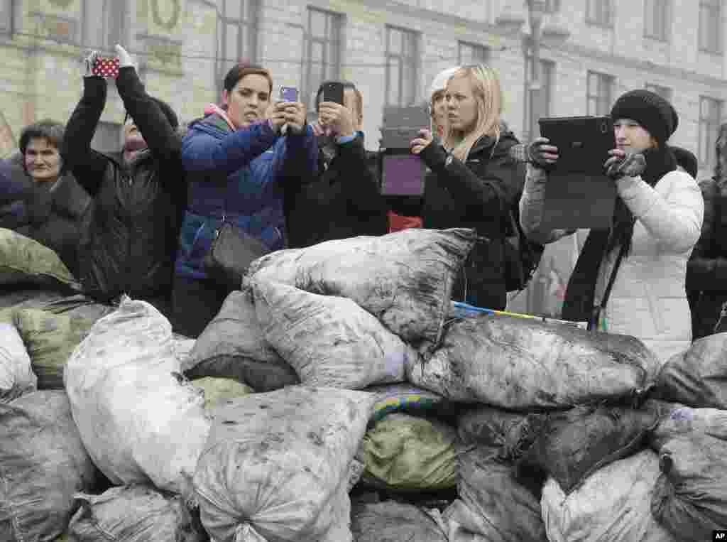 Tourists take photos of barricades in front of riot police in central Kyiv, Feb. 9, 2014.&nbsp;