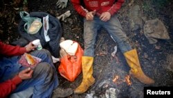 Rudari jedu u pauzi za ručak ispred ilegalnog rudnika ugljena u blizini bosanskog grada Viteza