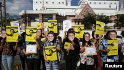 FILE - Demonstrators hold signs and masks as they protest on the six-month anniversary of pro-democracy activist Wanchalearm Satsaksit's abduction, in front of the Cambodian embassy in Bangkok, Thailand, December 3, 2020. (REUTERS/Soe Zeya Tun)