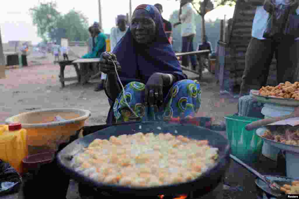 Seorang penjual kue di tepi jalan Kano, Nigeria, menjelang waktu berbuka puasa. 