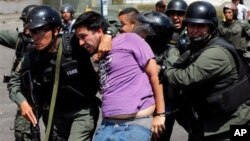 Miembros de la Guardia Nacional arrestan a un manifestante que se enfrentó a motociclistas armados partidarios del gobierno.