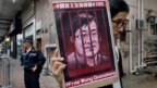 Một người biểu tình cầm một tấm hình của luật sư nhân quyền nổi tiếng Vương Toàng Chương đang bị cầm tù bên ngoài văn phòng liên lạc của Trung Quốc ở Hong Kong hôm 13/7/2018.