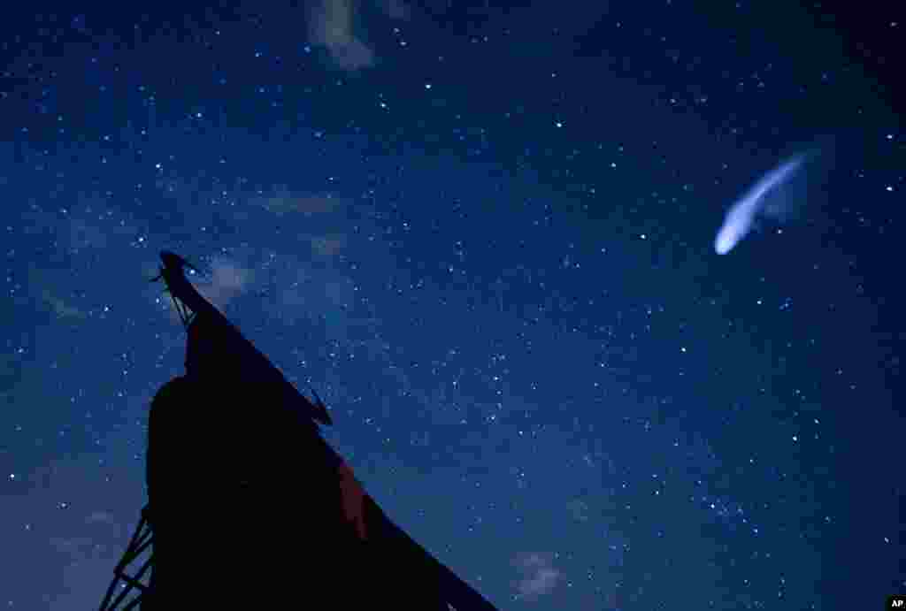 A streak appears in the sky during the annual Perseid meteor shower above a roadside silhouette of a Spanish fighting bull, conceived decades ago in Villarejo de Salvanes, Spain.