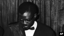 Patrice Lumumba, waziri mkuu wa Congo akitia saini tangazo la uhuru mjini Leopodville, Congo. Kulia kwake ni waziri mkuu wa zamani wa Ubelgiji Gaston Eyskens, aliyretia saini kwa niaba ya Ubelgiji. Ubelgiji iliitawala Congo kwa miaka 70.