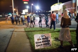 Demonstrators, marking the one-year anniversary of the shooting of Michael Brown, protest along West Florrisant Street on August 11, 2015 in Ferguson, Missouri.
