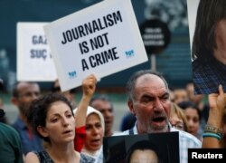 FILE - Demonstrators shout slogans during a protest against the arrest of three prominent activists for press freedom, in central Istanbul, Turkey, June 21, 2016.