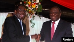 Rais wa Zimbabwe Robert Mugabe (L) akipeana mikono na Waziri Mkuu Morgan Tsvangirai, Harare, May 22, 2013.