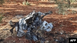 This picture taken on Sept. 20, 2021, shows a vehicle destroyed by what is believed to be a drone strike, on the northeastern outskirts of Syria's rebel-held northwestern city of Idlib. 