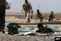 FILE - Iraqi Kurdish forces fight Islamic State militants in the Iraqi village of Bashir, June 29, 2014.