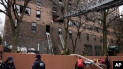 消防队员和警察在纽约市布朗克斯区一座失火公寓楼外执行任务。(2022年1月9日)