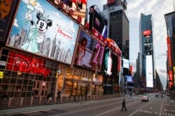 Beberapa polisi terlihat melakukan penjagaan di Times Square, New York di tengah perintah untuk tetap tinggal di rumah oleh Gubernur New York.