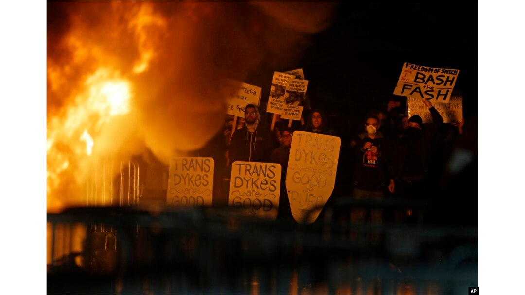 Protestors watch a fire on Sproul Plaza during a rally against the scheduled speaking appearance by Breitbart News editor Milo Yiannopoulos on the University of California at Berkeley campus on Wednesday, Feb. 1, 2017, in Berkeley, Calif.